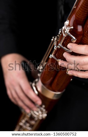 Wooden bassoon isolated on a black background. Musical instruments. Musician playing the instrument. Royalty-Free Stock Photo #1360500752