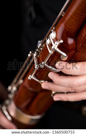 Wooden bassoon isolated on a black background. Musical instruments. Musician playing the instrument. Royalty-Free Stock Photo #1360500755