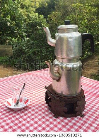 Teapot and glass of tea on outdoor picnic table