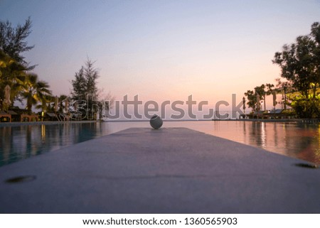 The ball in the pool, the background is the sea and the sky.