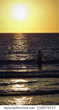 Young boy swimming at sunset on Marco Island in Florida.