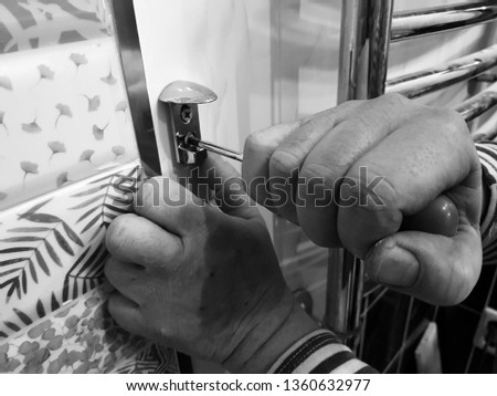 Construction and repair - a professional tool and screwdriver in the hands of the builder-plumber