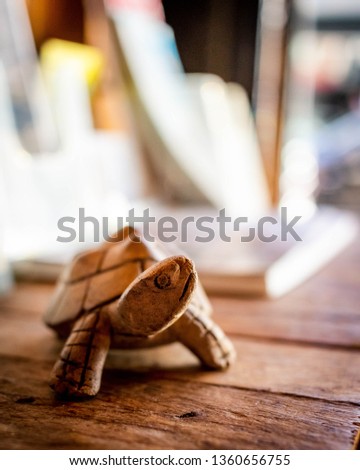 Wood carved Turtle bathing in sunlight, on shelf in a coffee shop.