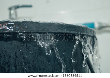 The water is overflowing from the black water tank. Royalty-Free Stock Photo #1360684511