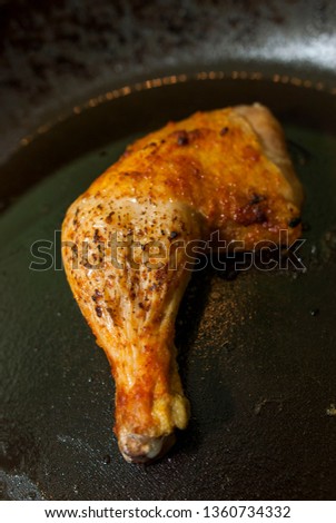 roast chicken drumstick in a black frying pan