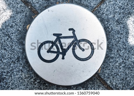 Sign of the bike path on the asphalt in the park. Close-up.