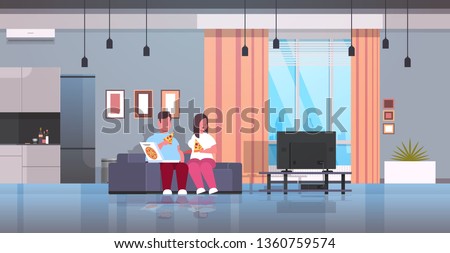 over size couple eating pizza man woman watching tv sitting on couch unhealthy fast food obesity concept modern living room interior full length flat horizontal