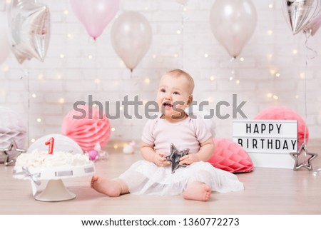 first birthday concept - funny dreaming girl and smashed birthday cake with lights, stars and air balloons