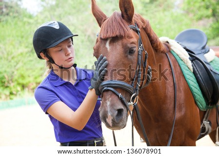 young woman rider and horse are friends Royalty-Free Stock Photo #136078901