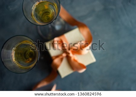 White sparkling wine and gift box concept on grey concrete background with copy space