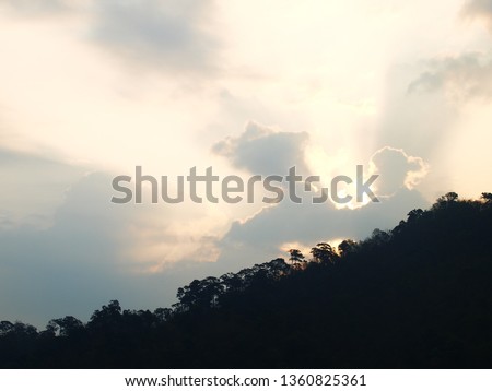 sunrise sunset twilight time dark colour scene tropical hills trees mountain view silhouette surrounding with green tropical natural environment in dark shadow under cloudy sky