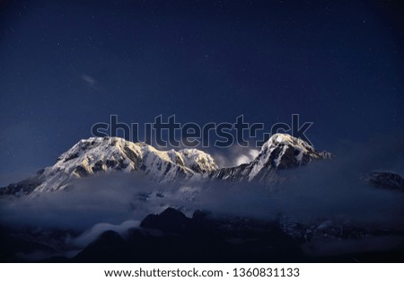 Snowy Annapurna and Hinchuli mountains at night starry sky in Nepal 