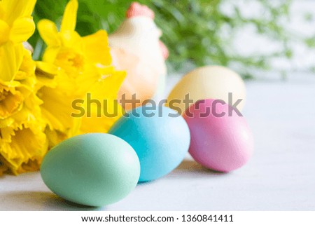 Spring daffodils and colorful easter eggs on blurred background