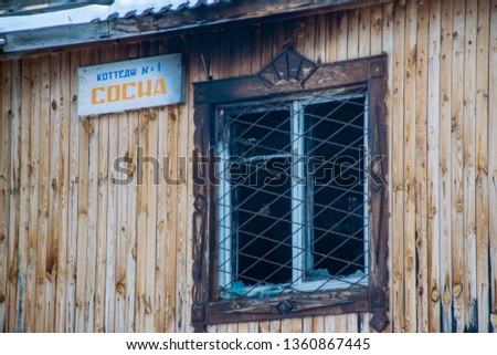 The abandoned wooden house in Askat village in Altai Mountains. Russian winter in Siberia. Translation is "Cottage number 1".