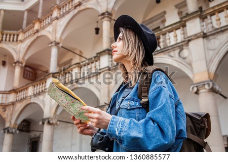 Young woman, professional photographer with camera in old castle. Traveler concept 