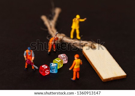 Discount sale concept. Miniature people with the label for clothes. Close up.