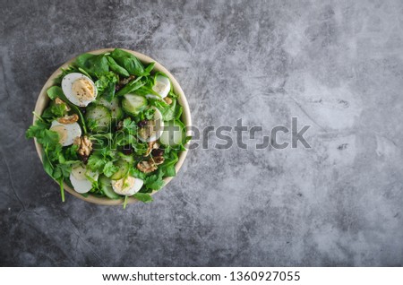 Delicious and simple healthy salad with nuts, eggs and cucumber