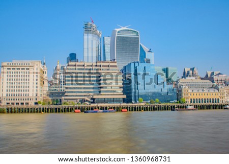 A Long Exposure view across the River Thames on a bright day to the cityscape architecture