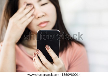 Asian woman rubbing eye pain feeling tired from watching screen of smart phone 