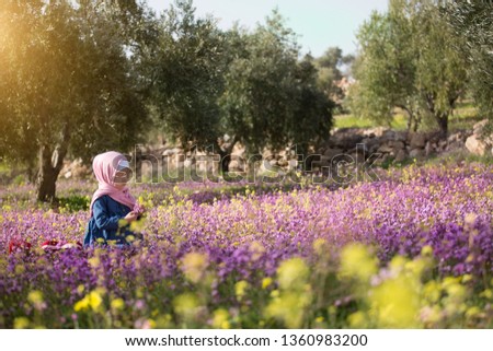 muslim girl in hijab, praying on the beautiful spring or summer meadow. Ramadan concept