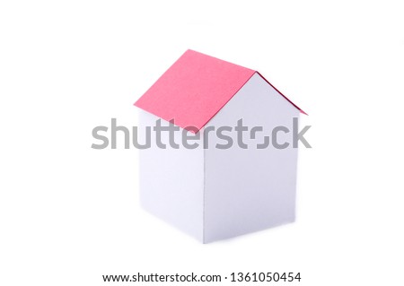 A paper house with red roof on white background.