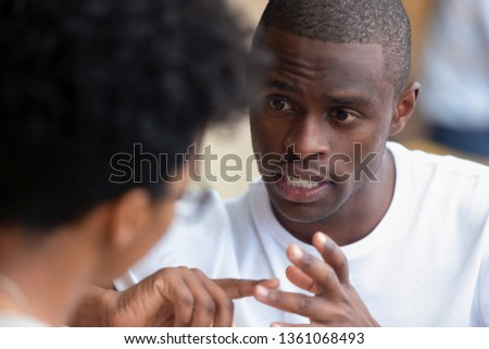 Focused african american man looking speaking to woman having business talk negotiating explaining, serious black guy having conversation with girlfriend friend discussing important issues at meeting Royalty-Free Stock Photo #1361068493