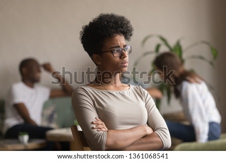 Sad frustrated mixed race girl loser feeling jealous offended sitting alone in cafe after fight with friends being rejected, upset african american student outcast bully victim suffer from jealousy Royalty-Free Stock Photo #1361068541