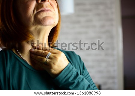 Woman thyroid gland control. Senior lady sweeping the laryngeal, laryngitis, goiter or Hypothyroidism. Disorder of the endocrine system. Hashimoto’s Thyroiditis, Lymphocytic Thyroiditis. Royalty-Free Stock Photo #1361088998
