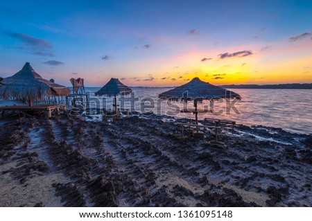 Wooden gazebo in the beach with beautiful light of sunrise. This photo take in the one of beautiful beach Batam island Indonesia.