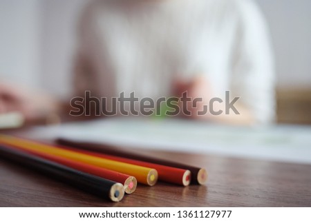 blurred of girl draws with pencils, selective focus