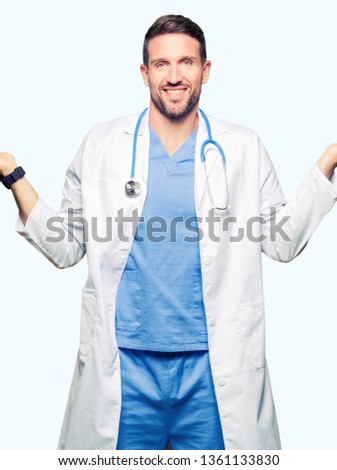 Handsome doctor man wearing medical uniform over isolated background Smiling showing both hands open palms, presenting and advertising comparison and balance