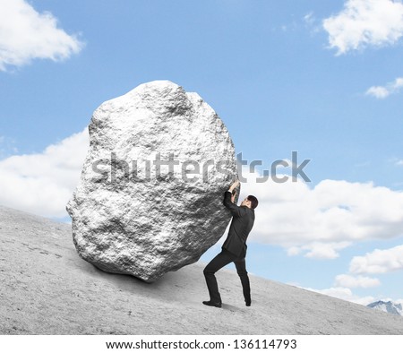 businessman pushing stone up hill and sky