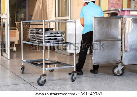 Woman nurse prepare food on cart at hospotal for patient.