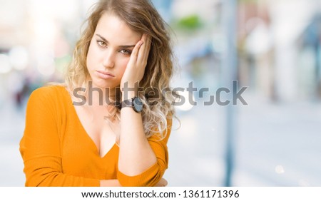 Beautiful young blonde woman over isolated background thinking looking tired and bored with depression problems with crossed arms.