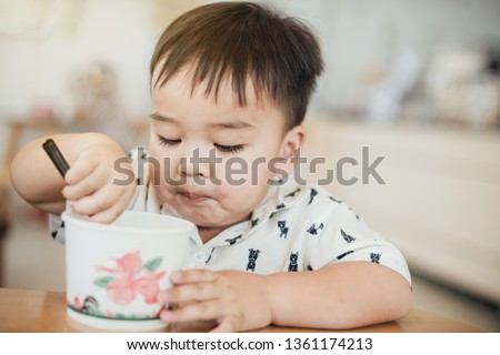 Cute happy baby boy  eating ice cream in summer. Picture for concept of sweet ,fat ,obesity and diabetes in children.