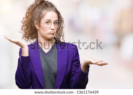 Young brunette student girl wearing school uniform and glasses over isolated background clueless and confused expression with arms and hands raised. Doubt concept.
