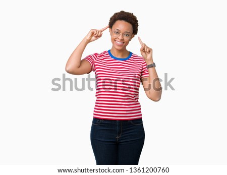 Beautiful young african american woman wearing glasses over isolated background Smiling pointing to head with both hands finger, great idea or thought, good memory