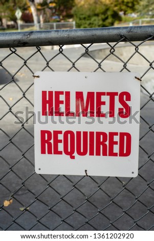 skatepark sign HELMETS REQUIRED red lettering on white