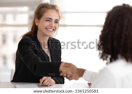 Happy businesswoman hr manager handshake hire candidate selling insurance services making good first impression, diverse broker and client customer shake hand at business office meeting job interview Royalty-Free Stock Photo #1361250581