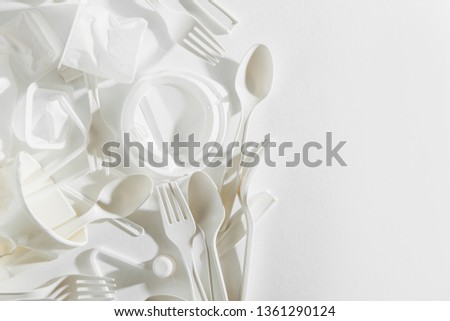 White single use plastic on  white background. Closeup. 
Concept of Recycling plastic and ecology. Flat lay, top view