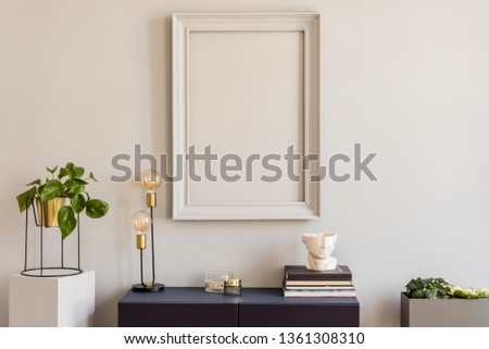 Scandi and design home decor with mock up grey poster frame, navy blue shelf with stylish accessories, lamp and books. Stylish and minimalistic room interior with big plants in gold pot. 