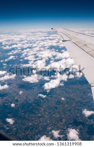 wing of the plane against the blue sky with clouds. view from eluminator to the wing of the aircraft against the sky. Concept: flight, vacation, tourism.
