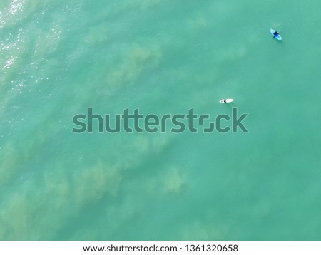 Aerial picture of surfers in Southern California ocean waiting for a wave. Beautiful greenish water.