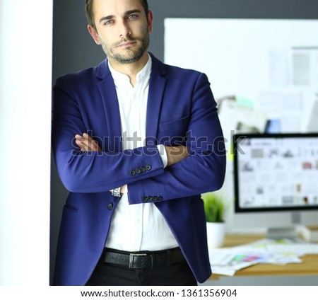 Portrait of young designer in front of laptop and computer while working.