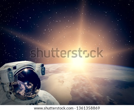 Astronaut looking at sunrise. The elements of this image furnished by NASA.
