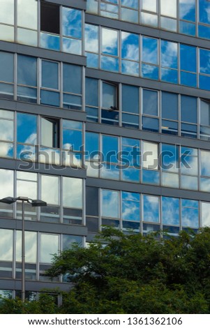 Texture background for design, glass windows and walls of buildings with reflections of streets, plants and palm trees.