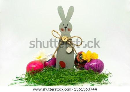 Easter bunny, eggs and flowers in the grass