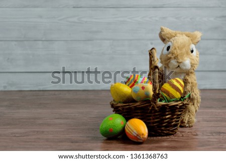 Easter eggs colored in basket with toy rabbit