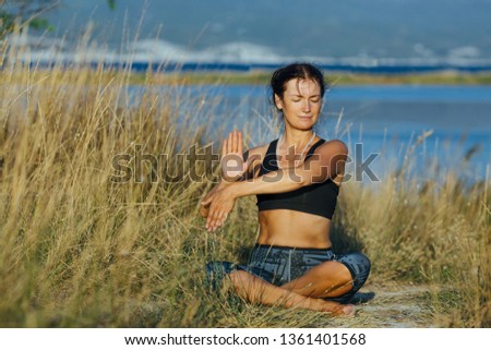 Healthy person young woman doing yoga exercise in morning  on the nature.