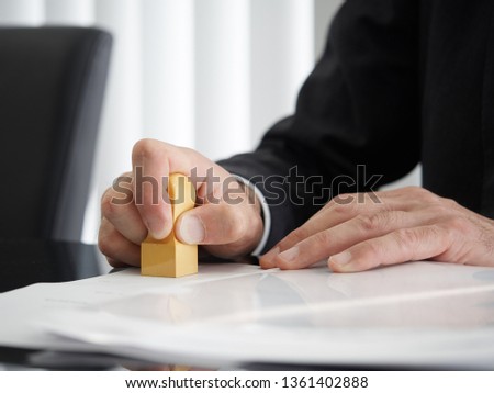 Hand of a judicial scrivener who puts a mark Royalty-Free Stock Photo #1361402888